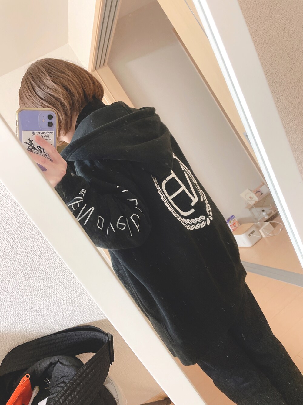 ベージュ系のカーディガン/ボレロ、ブラック系のパーカー、ブルー系のデニムパンツを着用したレディースの冬コーディネートの2枚目の写真