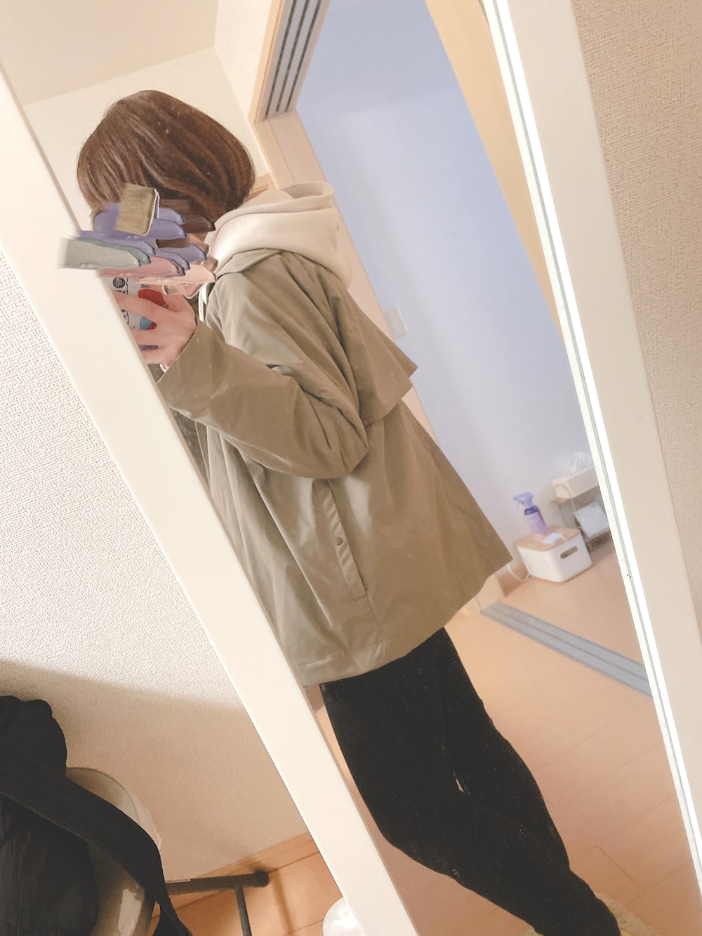 ホワイト系のパーカー、ブラック系のパンツ、ブラック系のショルダーバッグを着用したレディースの春コーディネートの3枚目の写真