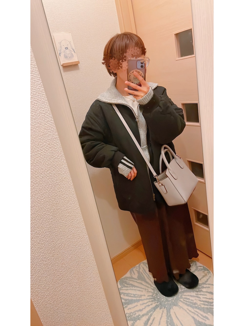 グレー系のワンピース、ブラック系のローファー、ブラック系のダウンジャケット/コートを着用したレディースの冬コーディネートの2枚目の写真