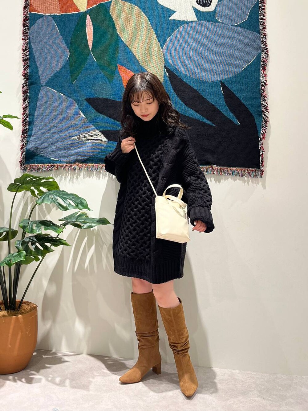 ブラウン系のブーツ、ホワイト系のショルダーバッグを着用したレディースの秋コーディネートの2枚目の写真