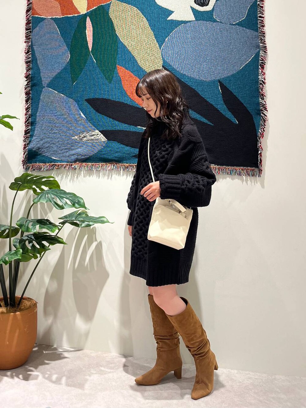 ブラウン系のブーツ、ホワイト系のショルダーバッグを着用したレディースの秋コーディネートの4枚目の写真