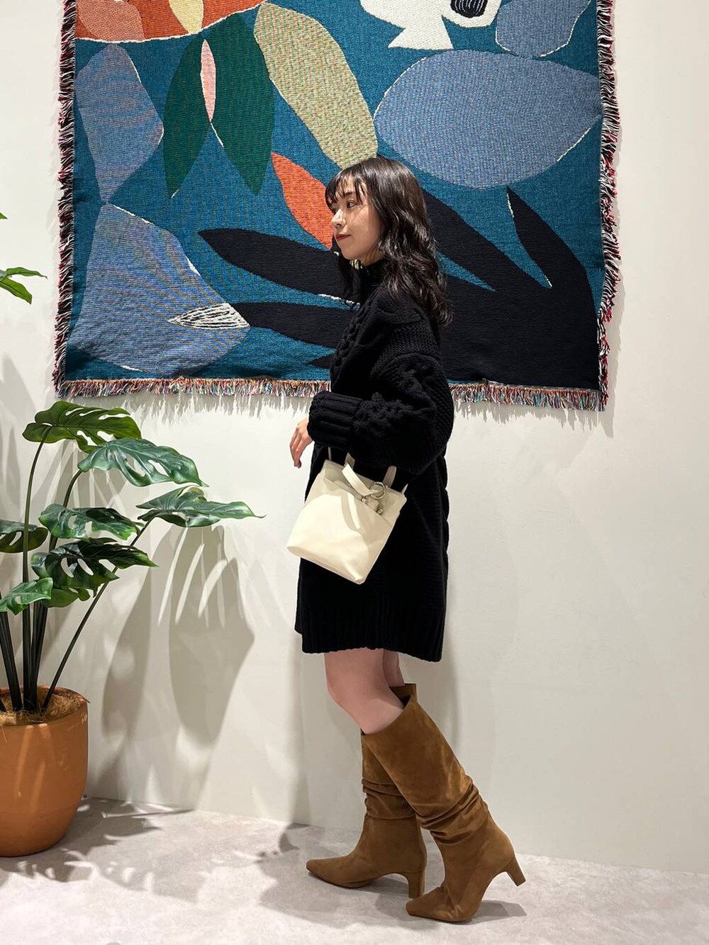 ブラウン系のブーツ、ホワイト系のショルダーバッグを着用したレディースの秋コーディネートの3枚目の写真