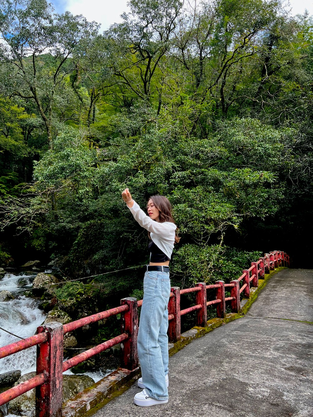 ホワイト系のカーディガン/ボレロ、ブラック系のキャミソール、ブルー系のデニムパンツを着用したレディースの秋コーディネートの2枚目の写真