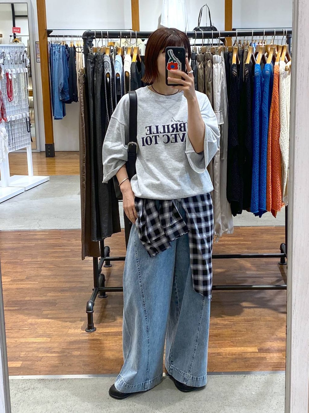 ブルー系のデニムパンツ、ブラック系のショルダーバッグ、ブラック系のその他シューズを着用したレディースの秋コーディネートの2枚目の写真