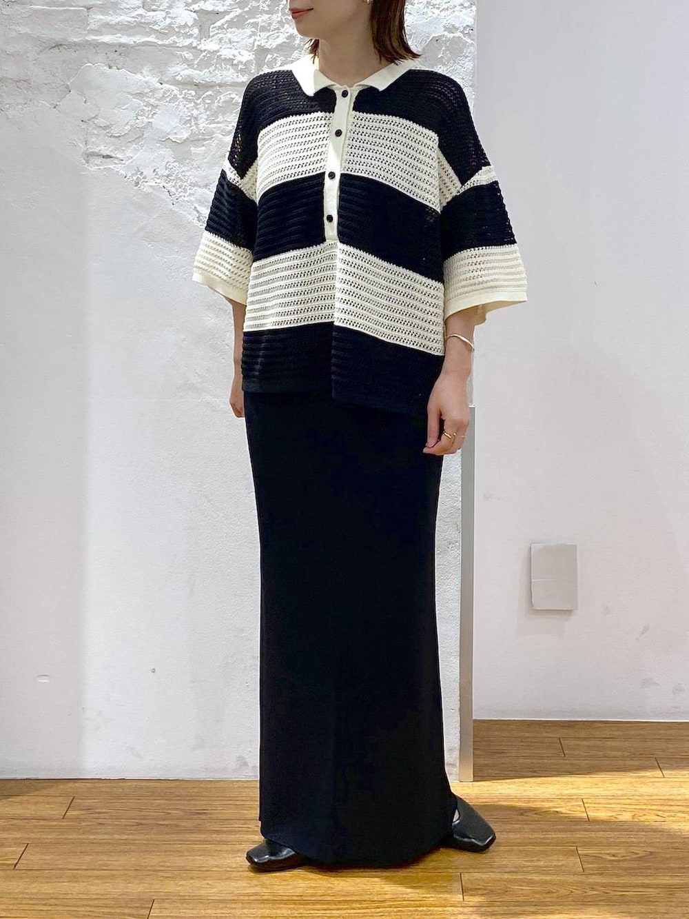 グレー系のキャミソール、ブラック系のパンプス、ブラック系のスカートを着用したレディースの夏コーディネートの2枚目の写真