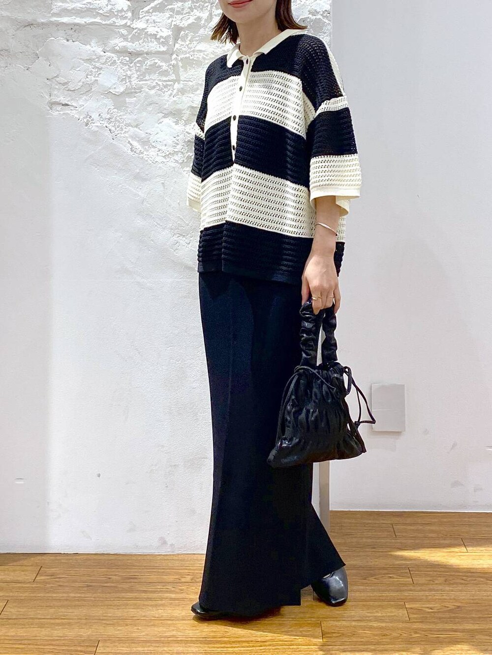 グレー系のキャミソール、ブラック系のパンプス、ブラック系のスカートを着用したレディースの夏コーディネートの5枚目の写真