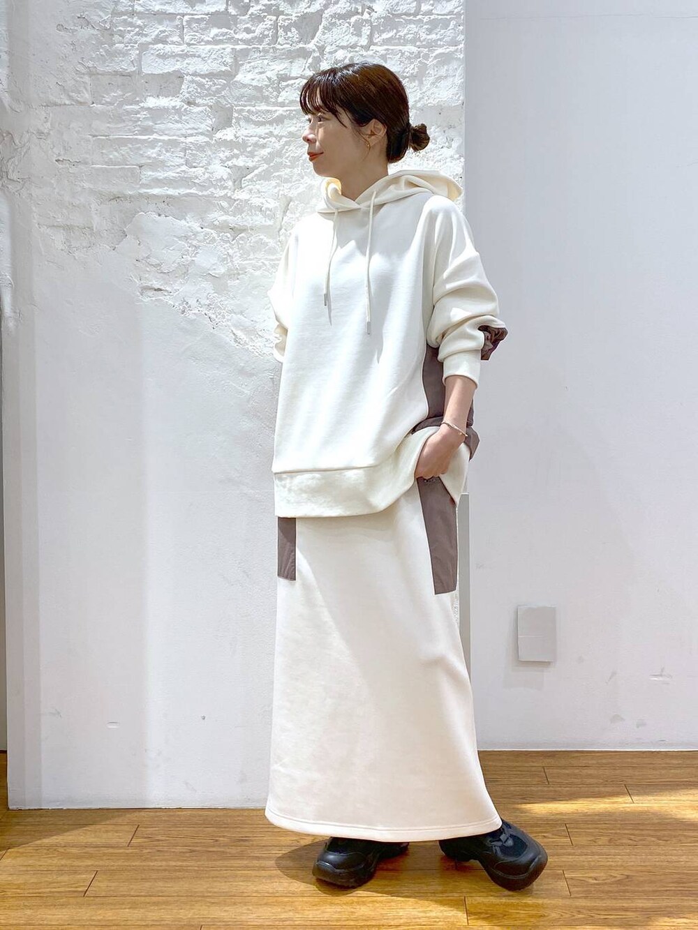 ホワイト系のショルダーバッグ、ブラック系のスニーカー、ホワイト系のパーカーを着用したレディースの秋コーディネートの5枚目の写真