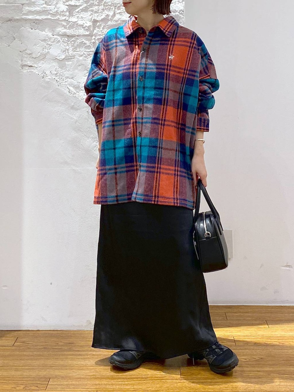 ブラック系のスカート、ブラック系のボストンバッグ、レッド系のシャツ/ブラウスを着用したレディースの秋コーディネートの2枚目の写真