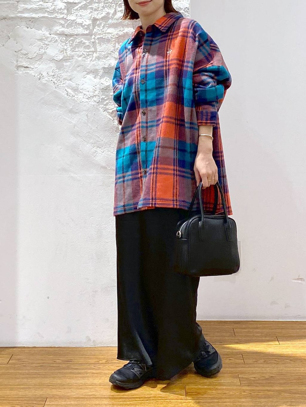 ブラック系のスカート、ブラック系のボストンバッグ、レッド系のシャツ/ブラウスを着用したレディースの秋コーディネートの3枚目の写真