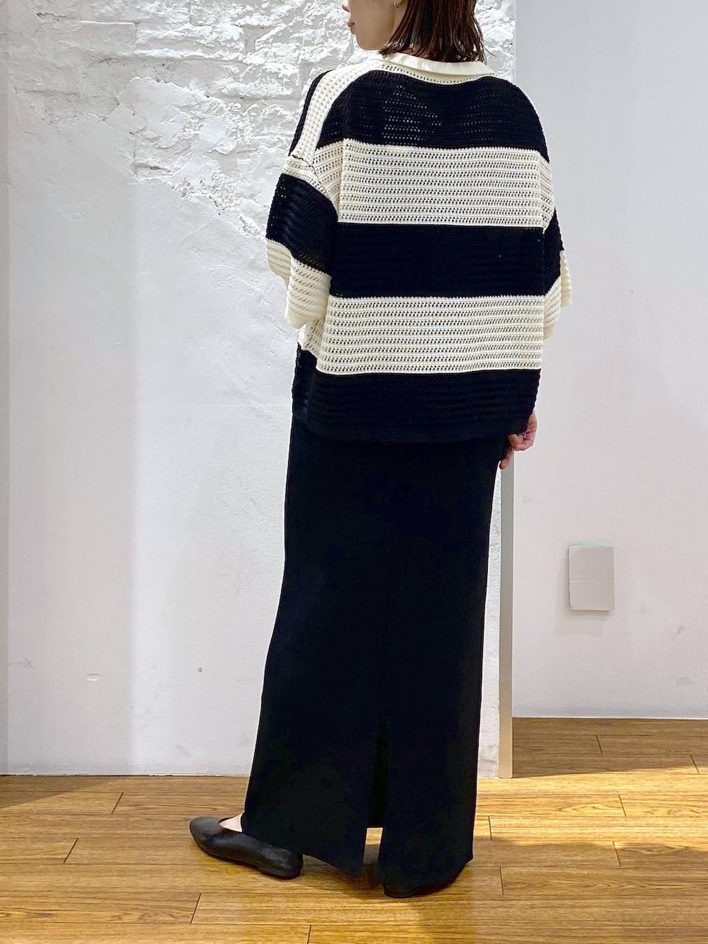 グレー系のキャミソール、ブラック系のパンプス、ブラック系のスカートを着用したレディースの夏コーディネートの4枚目の写真