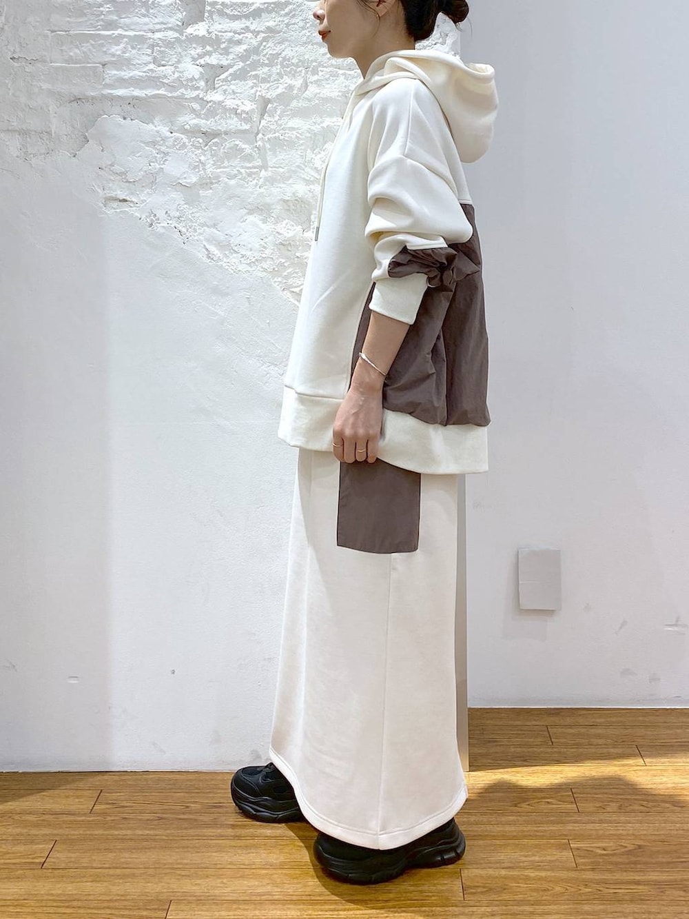 ホワイト系のショルダーバッグ、ブラック系のスニーカー、ホワイト系のパーカーを着用したレディースの秋コーディネートの4枚目の写真