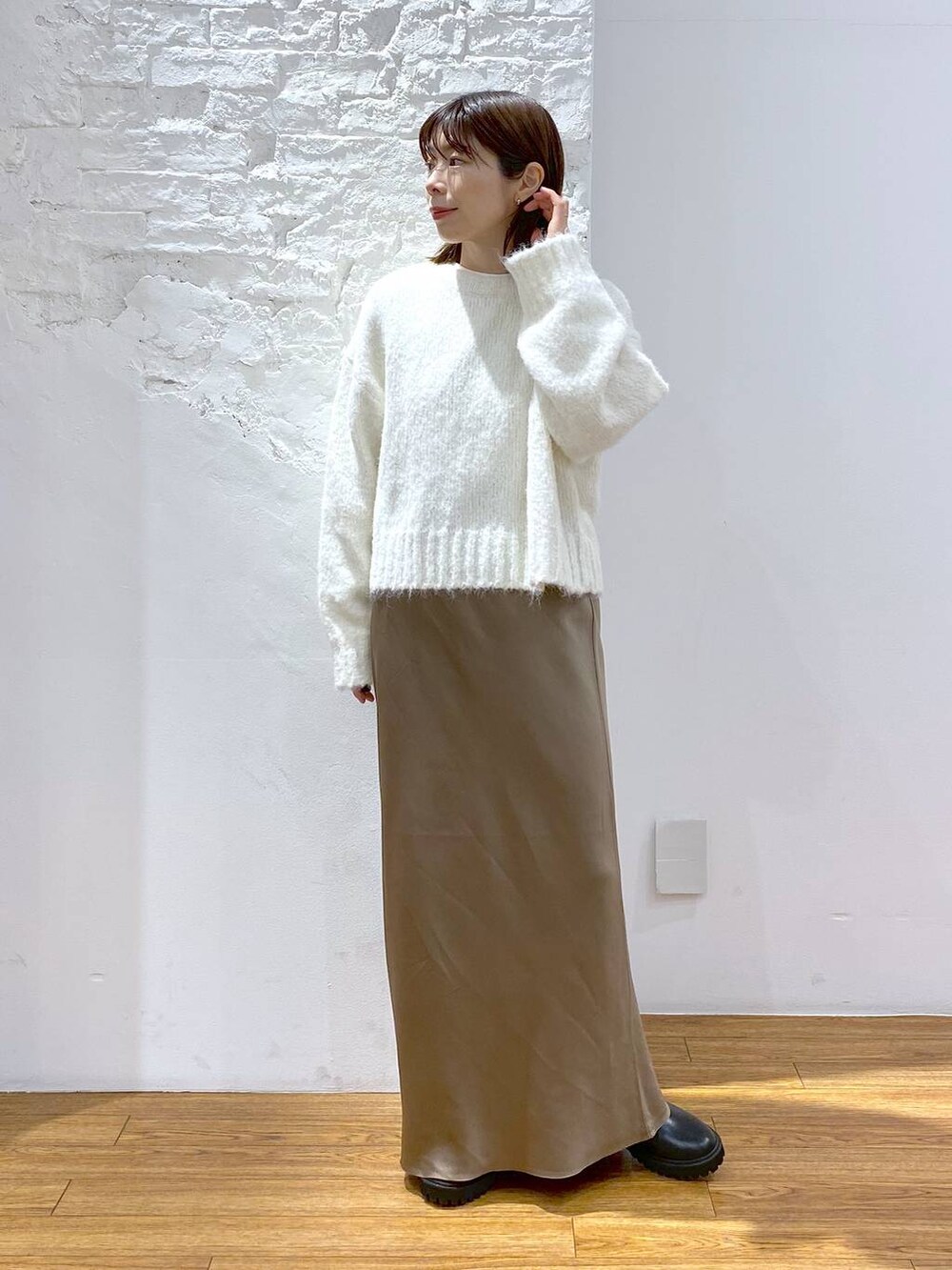 ブラック系のその他アウター、ブラック系のブーツ、ホワイト系のスカートを着用したレディースの冬コーディネートの4枚目の写真