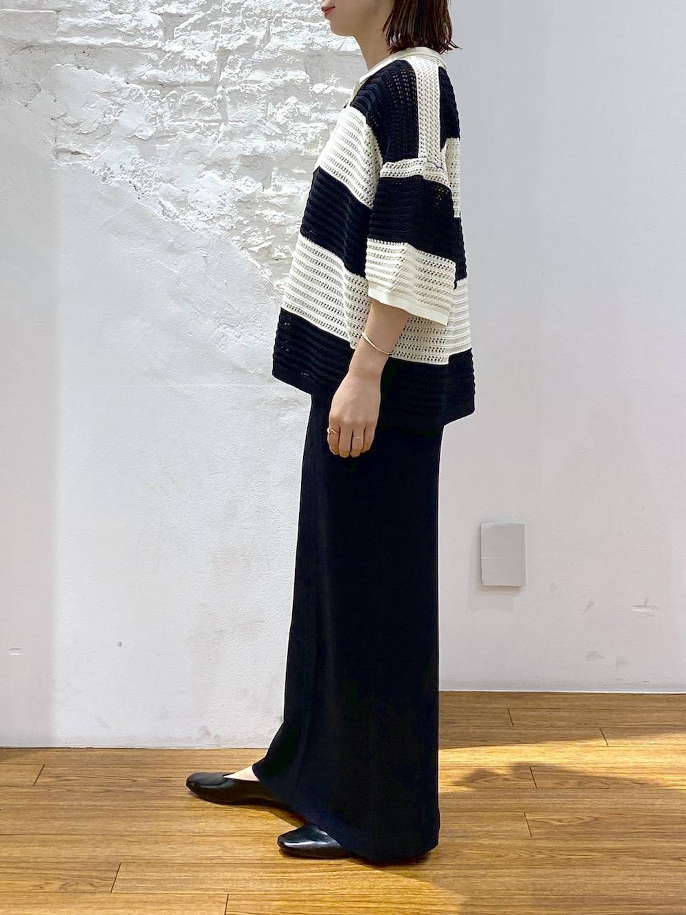 グレー系のキャミソール、ブラック系のパンプス、ブラック系のスカートを着用したレディースの夏コーディネートの3枚目の写真