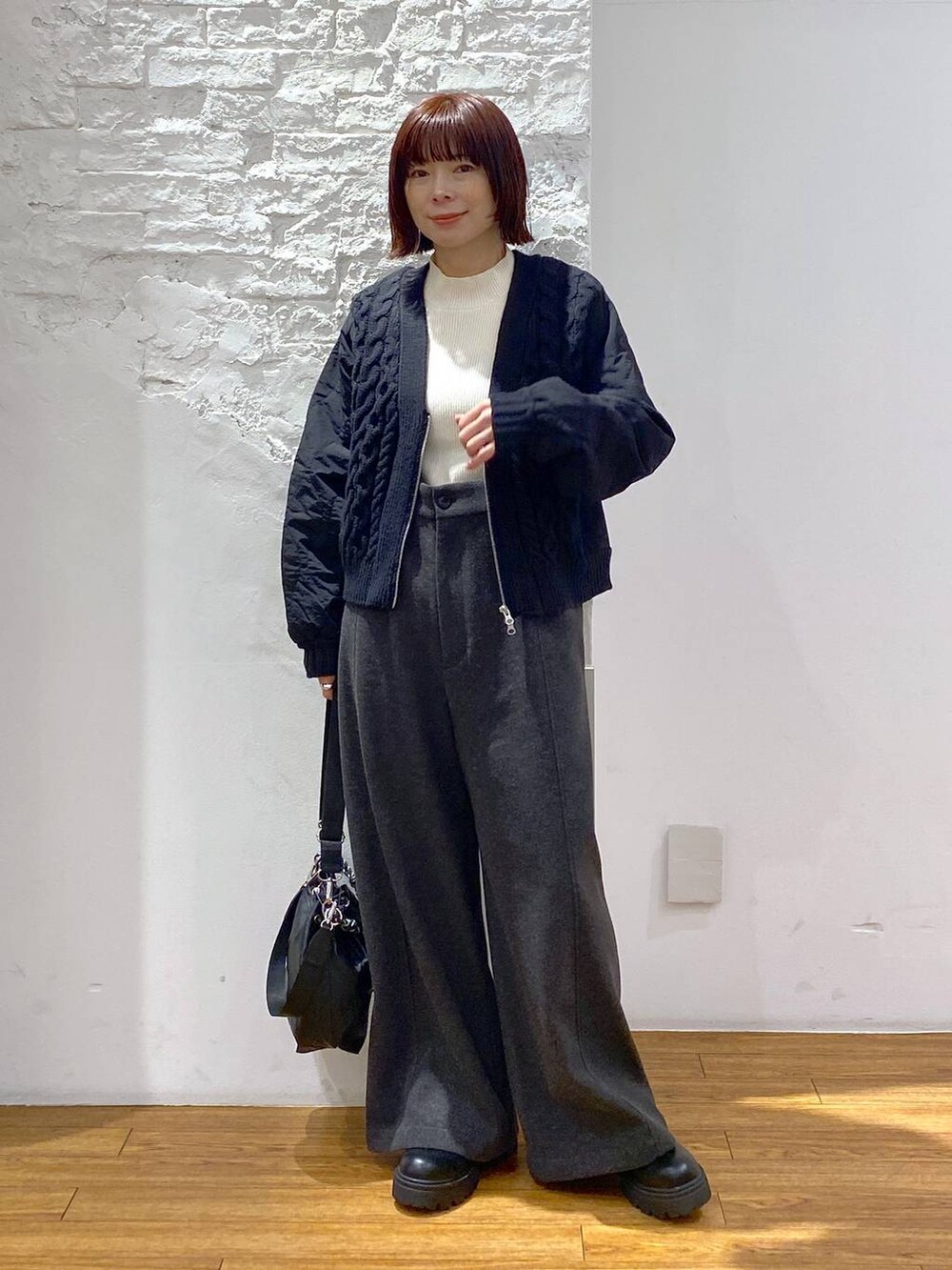 ブラック系のショルダーバッグ、グレー系のその他パンツ、ホワイト系のニット/セーターを着用したレディースの冬コーディネートの5枚目の写真