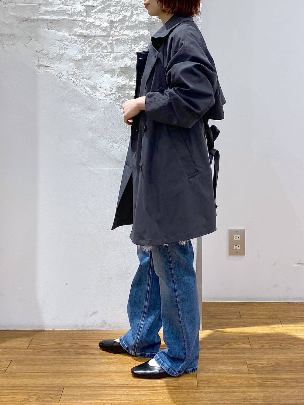 ブラック系のショルダーバッグ、グレー系のトレンチコート、ブラック系のパンプスを着用したレディースの春コーディネートの2枚目の写真