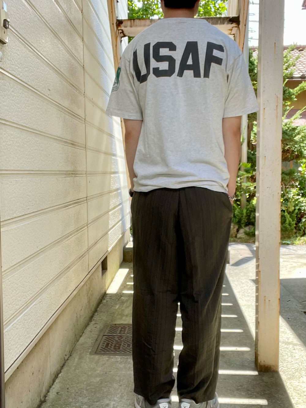 グレー系のスニーカー、グリーン系のスラックス、グレー系のTシャツ/カットソーを着用したメンズの夏コーディネートの2枚目の写真