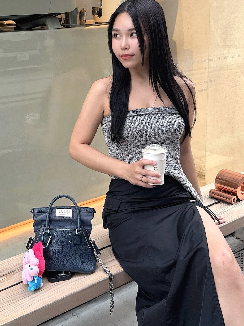 グレー系のトップス、ブラック系のスカート、ブラック系のサンダルを着用したレディースの秋コーディネートの2枚目の写真