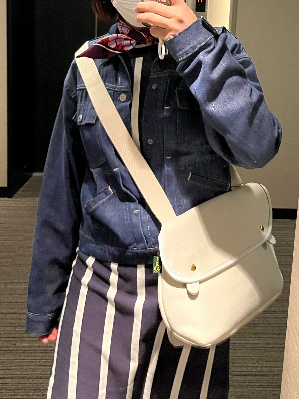 ブラック系のドレスシューズ、ブルー系のワンピース/ドレス、ホワイト系のショルダーバッグを着用したレディースの春コーディネートの2枚目の写真