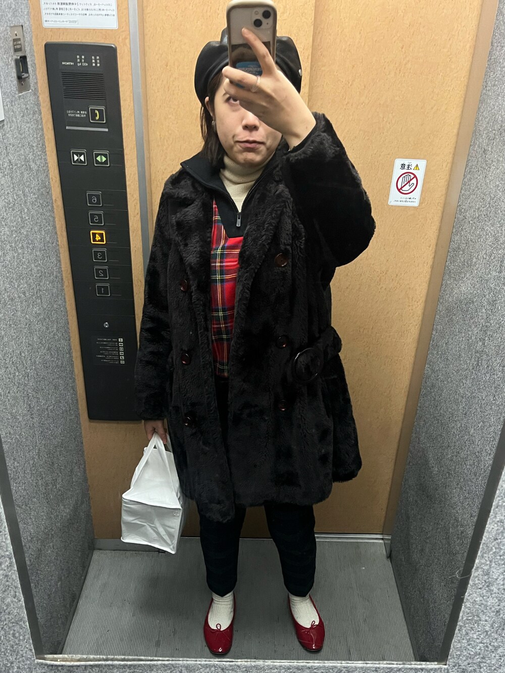 ブラック系のジャケット/アウター、レッド系のニット/セーター、ブラック系のその他パンツを着用したレディースの冬コーディネートの2枚目の写真