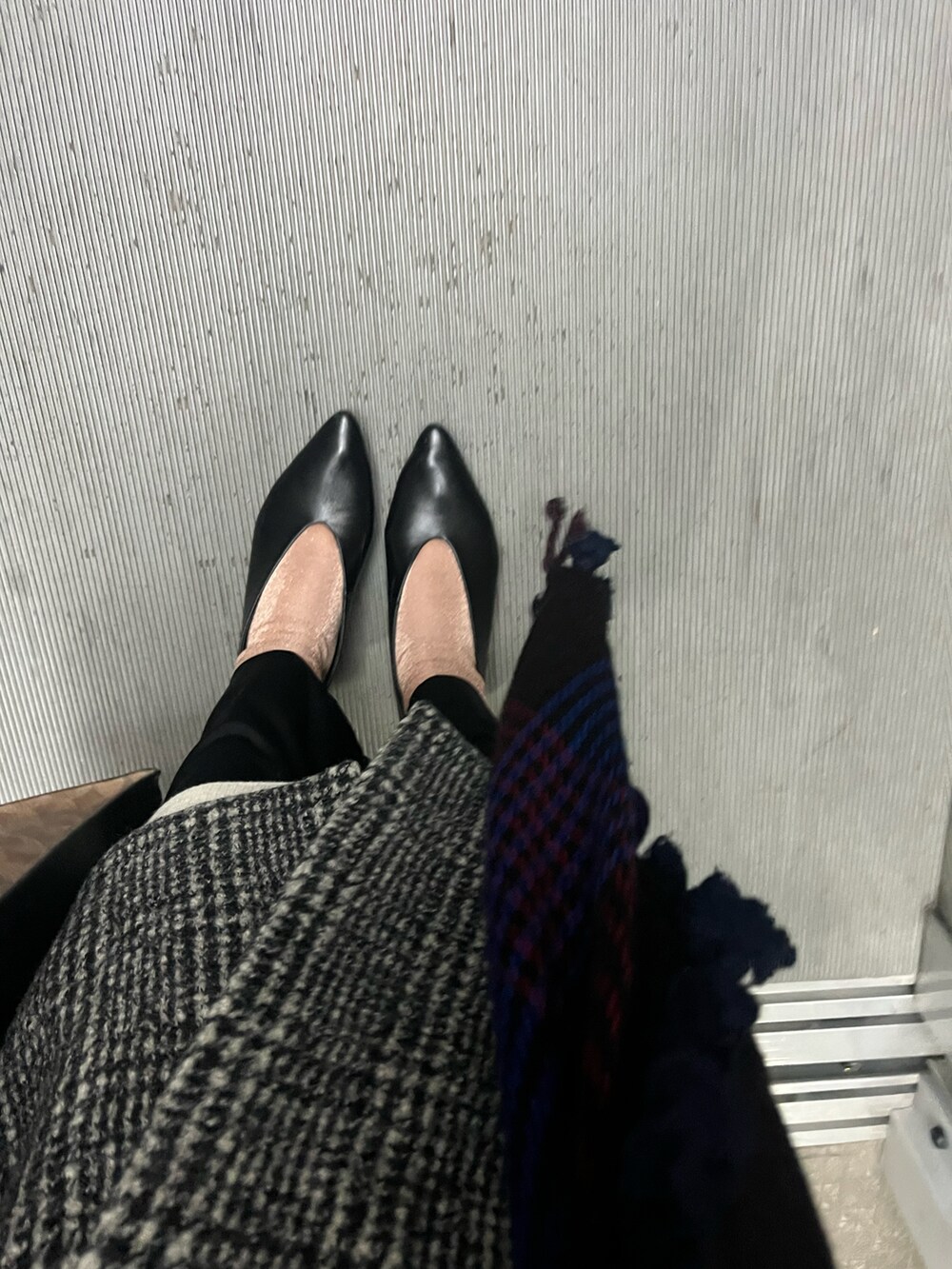 ブラック系のチェスターコートを着用したレディースの冬コーディネートの2枚目の写真