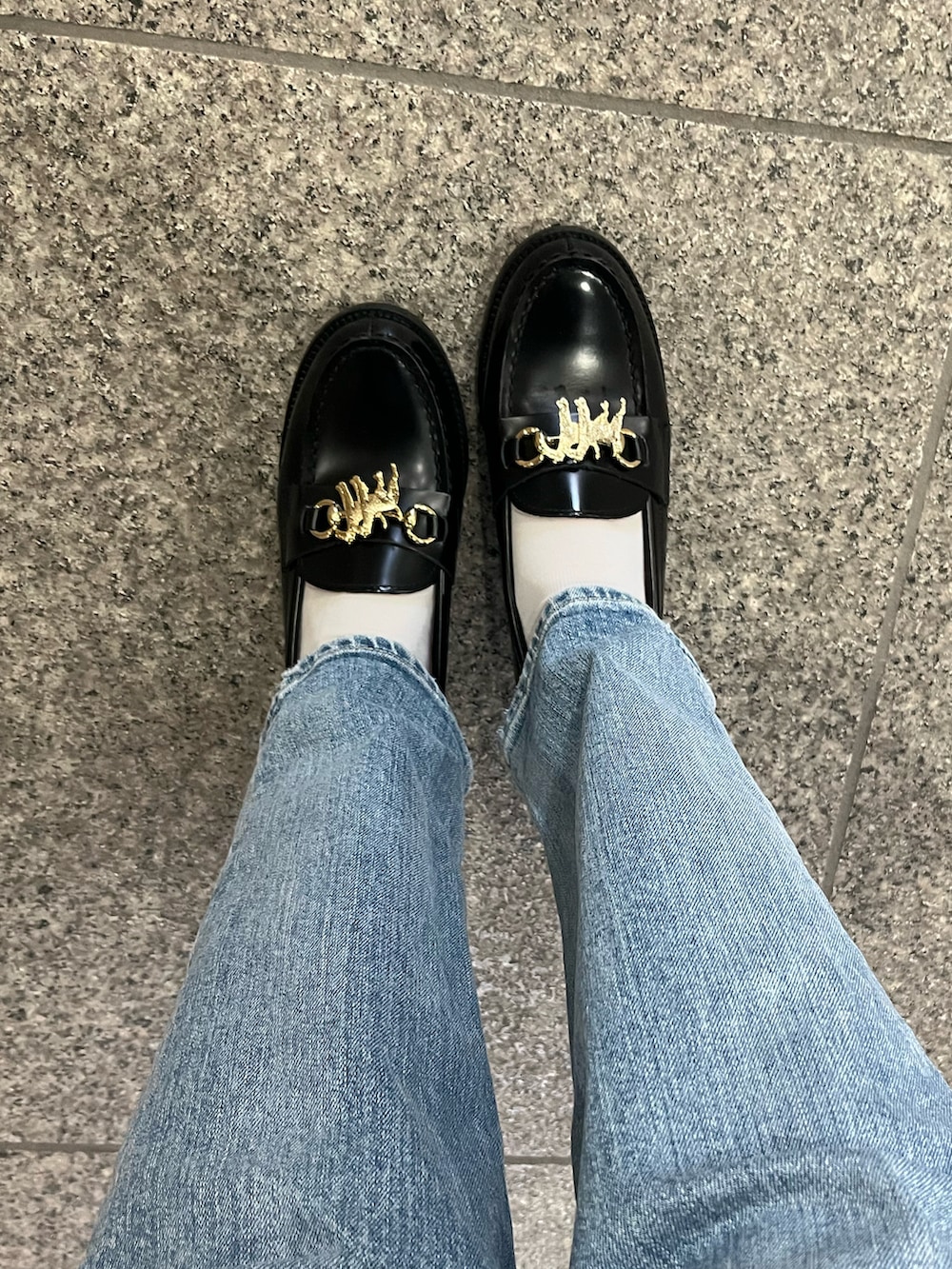 ベージュ系のトレンチコート、グレー系のニット/セーター、ブルー系のデニムパンツを着用したレディースの冬コーディネートの3枚目の写真