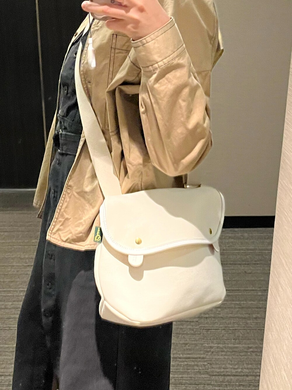 ホワイト系のスニーカー、ブラック系のワンピース、ベージュ系のトップスを着用したレディースの春コーディネートの2枚目の写真