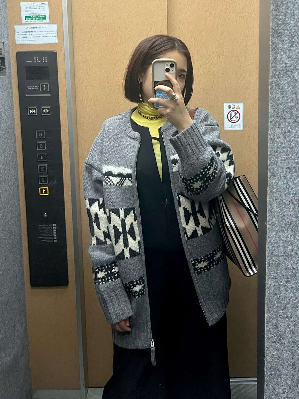 ブラック系のつなぎ/オールインワン、グレー系のカーディガン/ボレロを着用したレディースの冬コーディネートの2枚目の写真