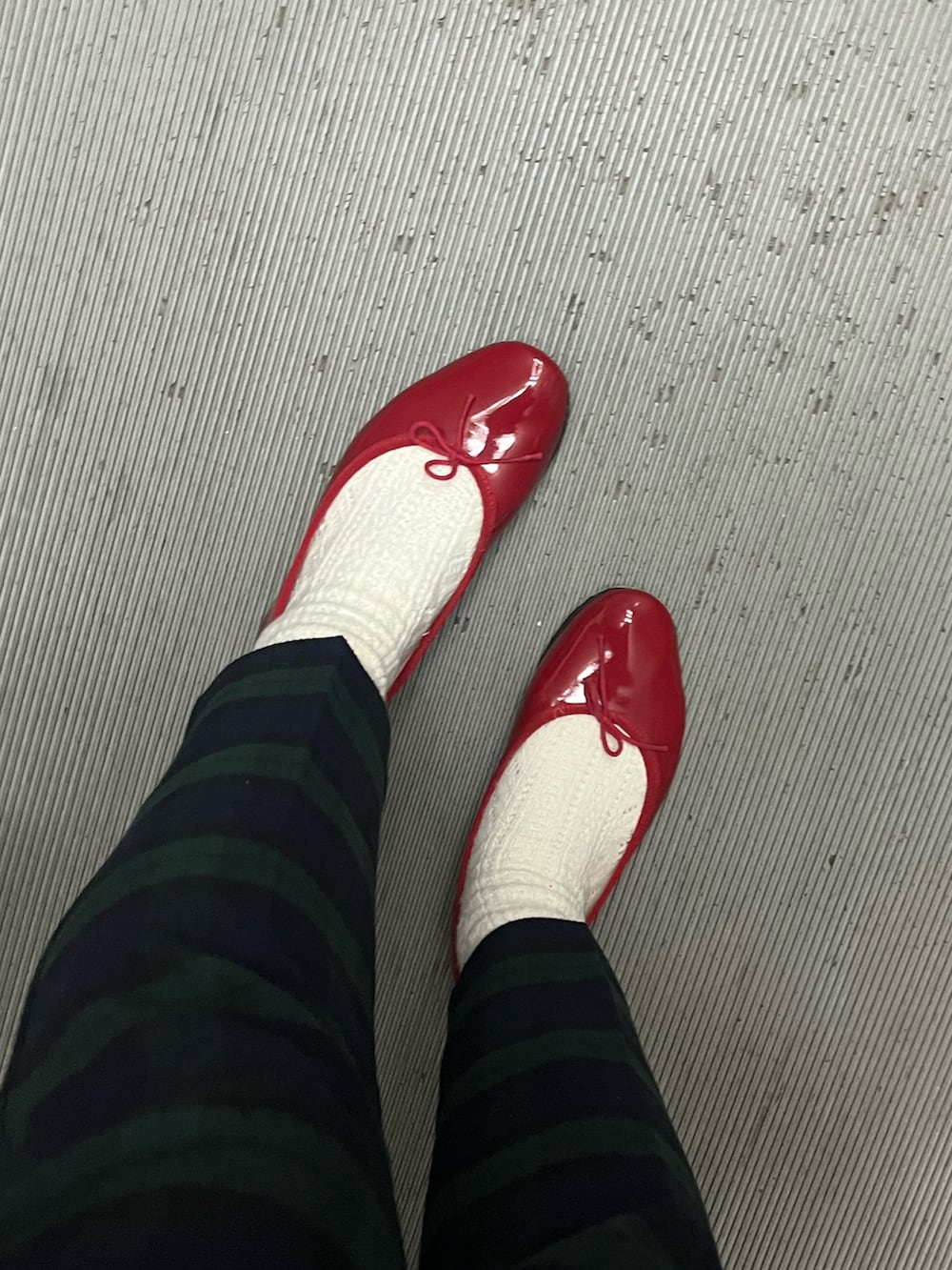 ブラック系のジャケット/アウター、レッド系のニット/セーター、ブラック系のその他パンツを着用したレディースの冬コーディネートの3枚目の写真