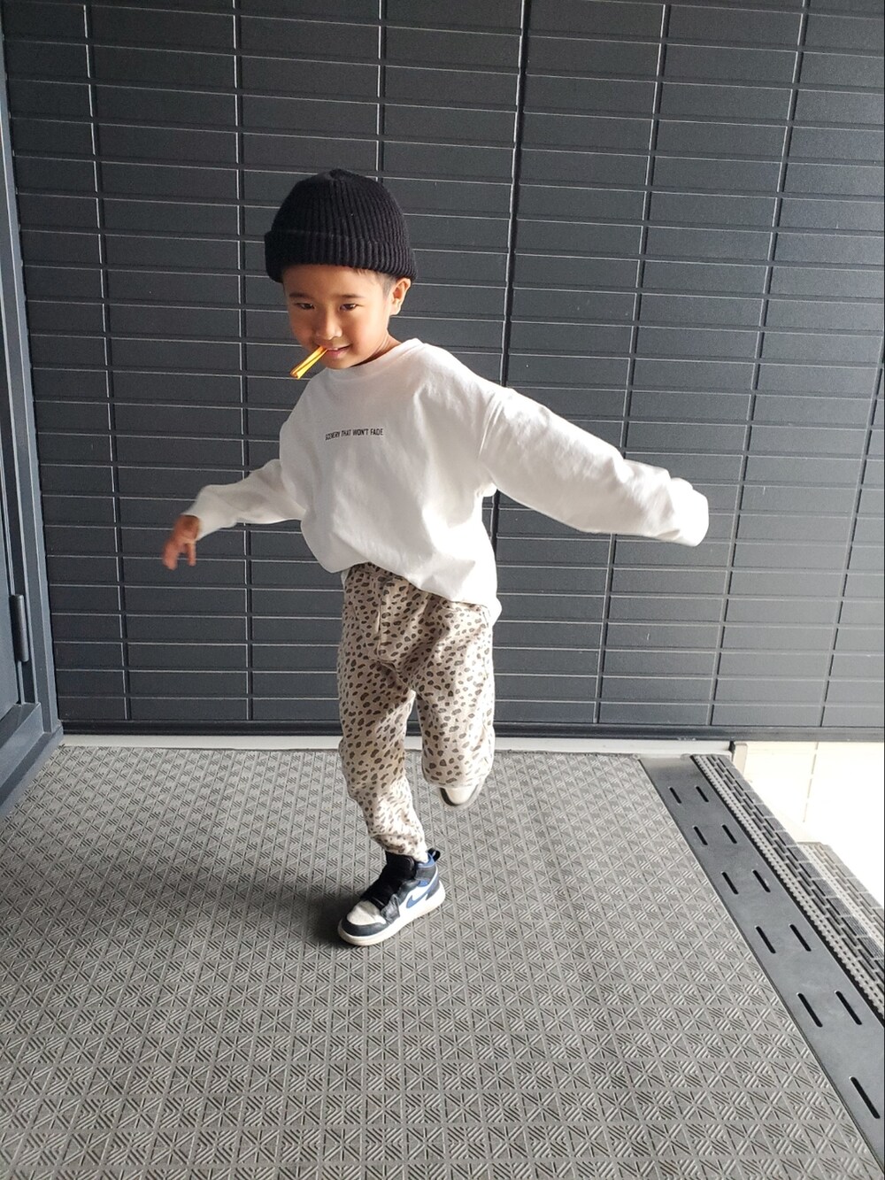 ホワイト系のTシャツ/カットソー、ホワイト系のスニーカー、ブラウン系のその他パンツを着用したキッズの春コーディネートの2枚目の写真