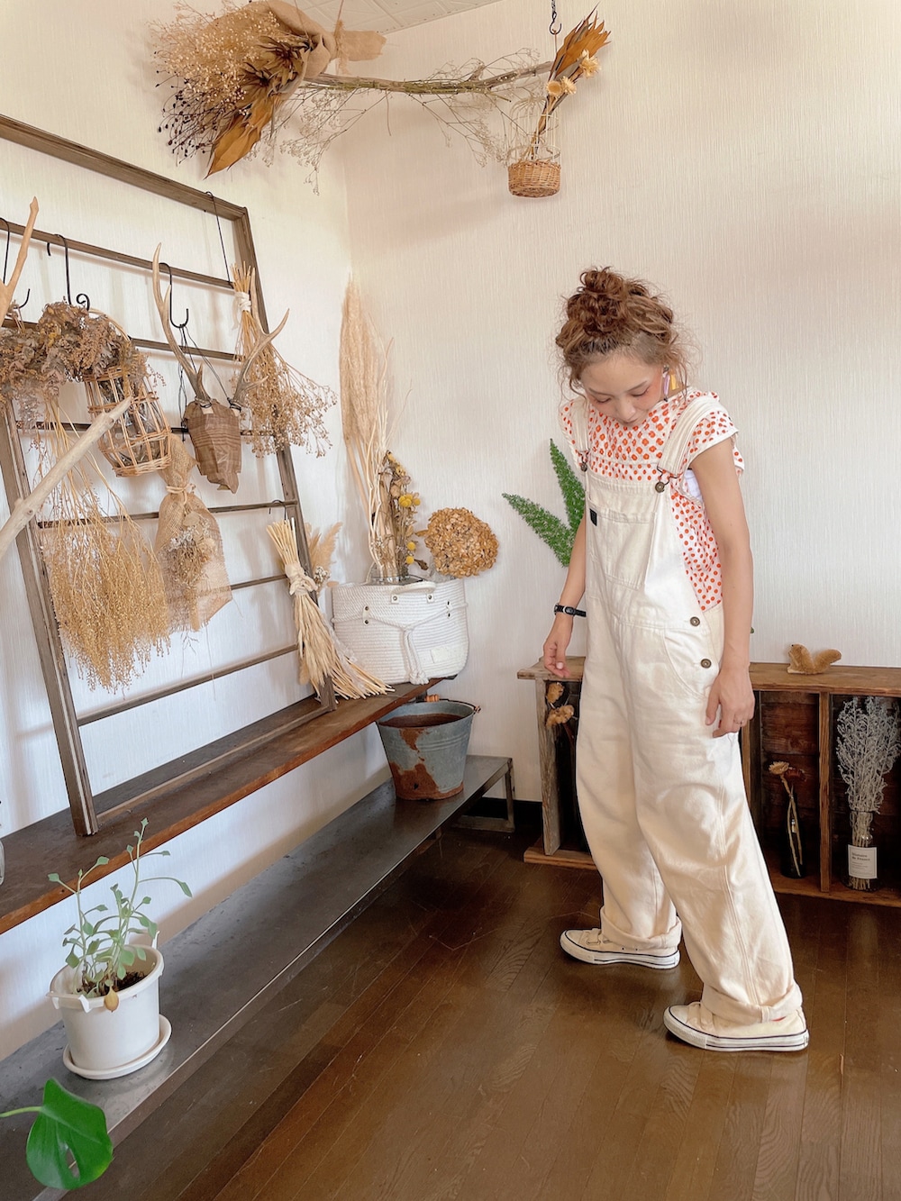 オレンジ系のシャツ/ブラウス、ホワイト系のサロペット/オーバーオール、ホワイト系のスニーカーを着用したレディースの夏コーディネートの2枚目の写真