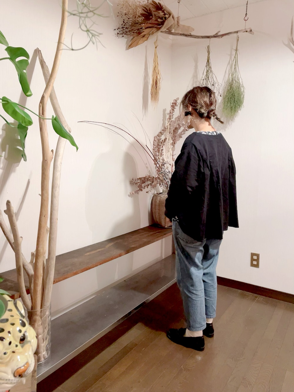 ブラック系のシャツ/ブラウス、ブラック系のTシャツ/カットソー、ブルー系のデニムパンツを着用したレディースの秋コーディネートの2枚目の写真