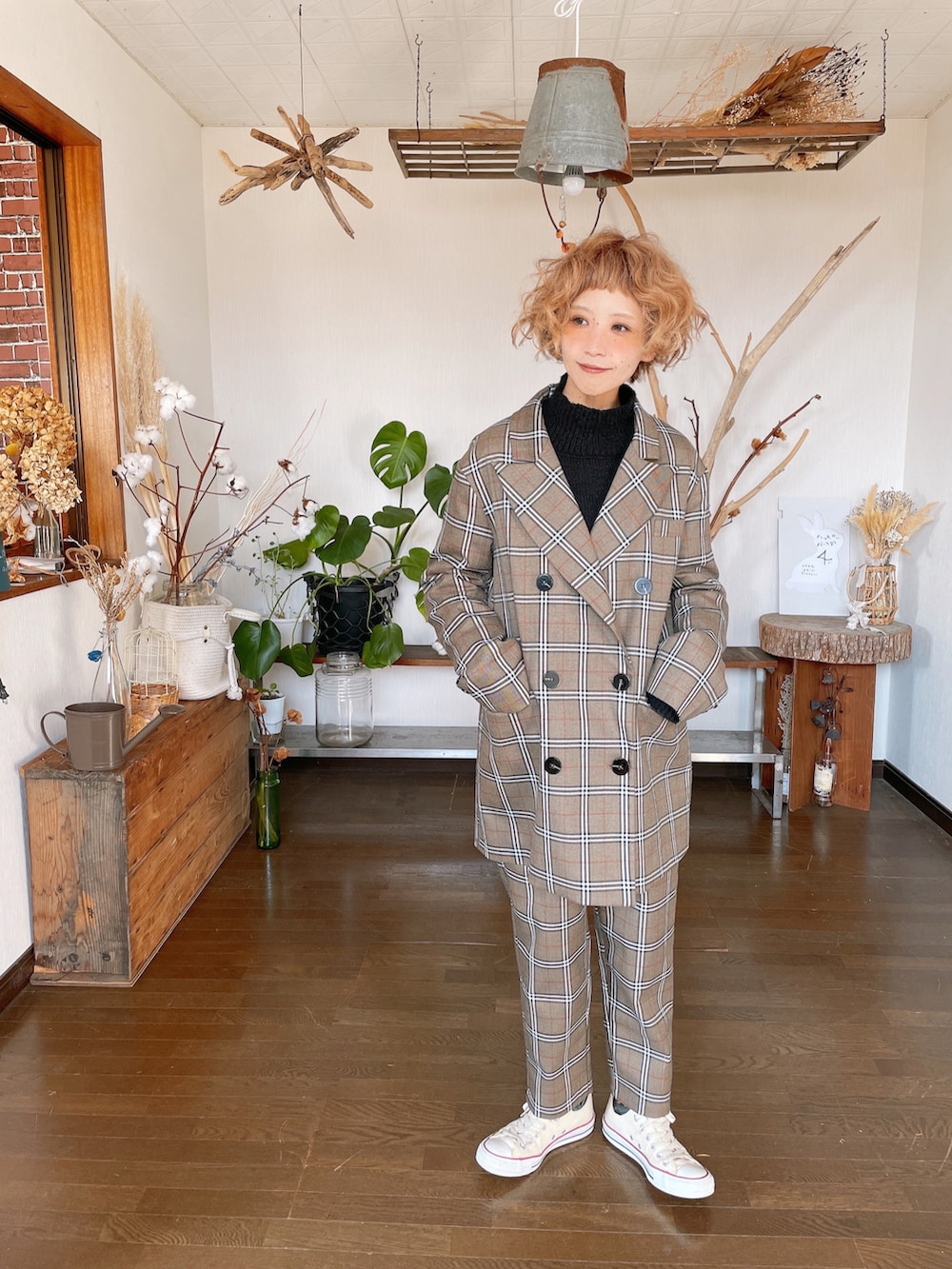 ブラウン系のスーツセット、ブラック系のニット/セーター、ホワイト系のスニーカーを着用したレディースの冬コーディネートの2枚目の写真