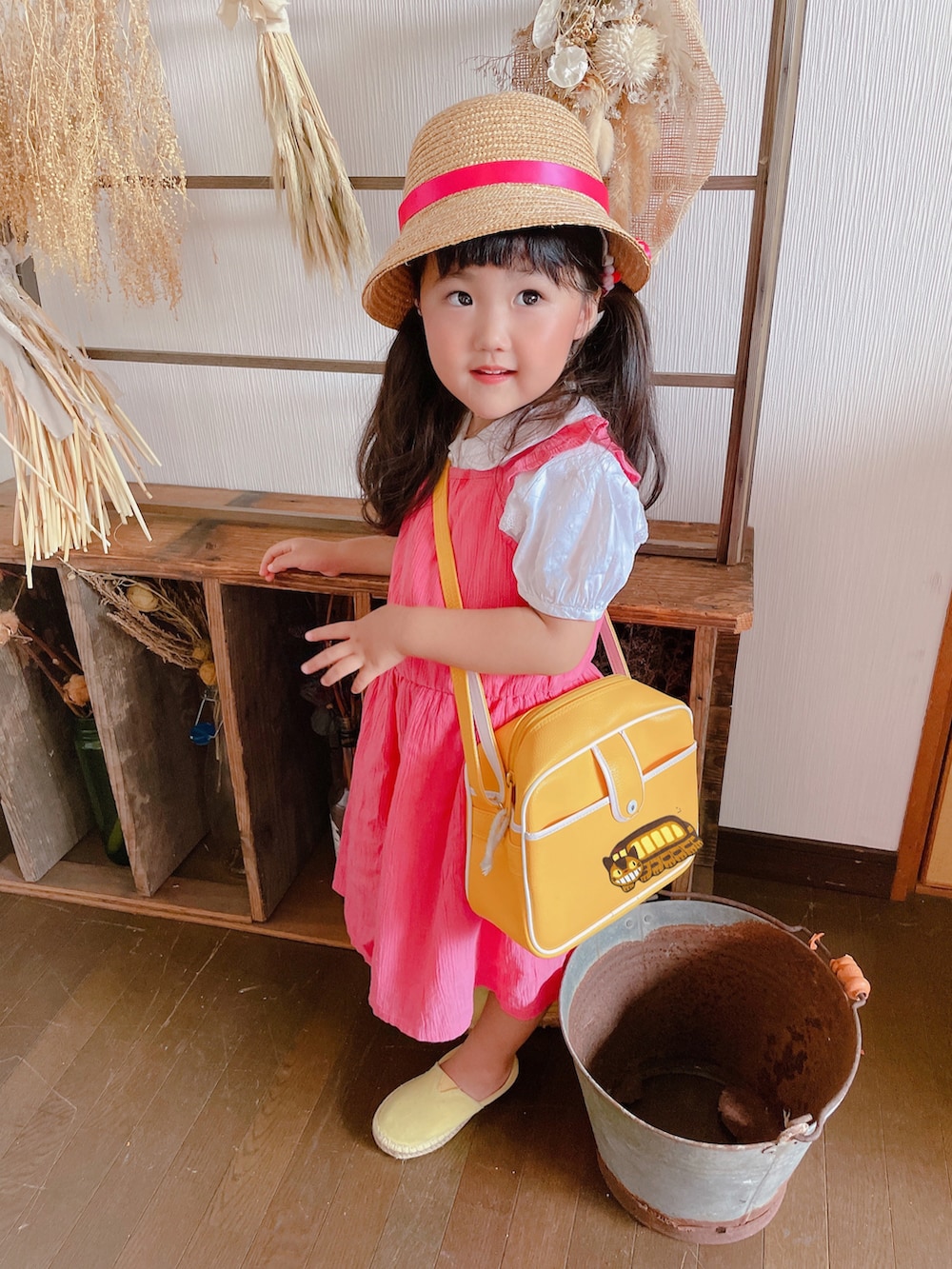 ピンク系のジャンパースカート、イエロー系のスニーカー、ピンク系のコスチューム/パーティーグッズを着用したキッズの夏コーディネートの4枚目の写真