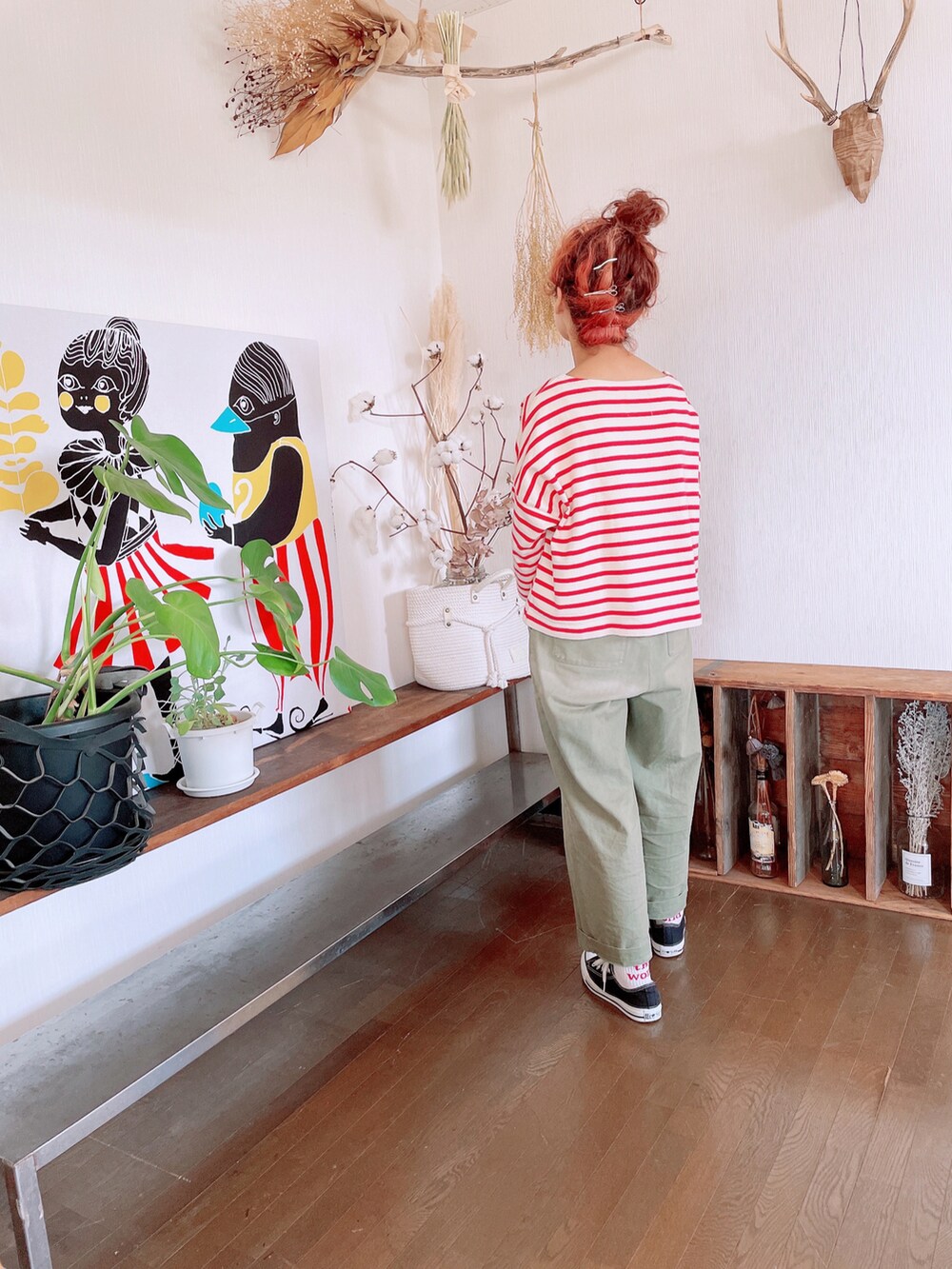 ベージュ系のTシャツ/カットソー、グリーン系のパンツ、ブラック系のスニーカーを着用したレディースの春コーディネートの2枚目の写真