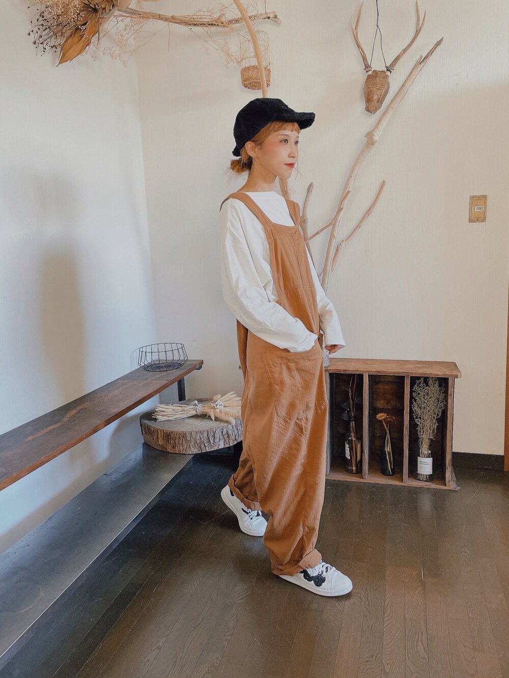 ホワイト系のTシャツ/カットソー、ブラウン系のサロペット/オーバーオール、ホワイト系のスニーカーを着用したレディースの秋コーディネートの2枚目の写真