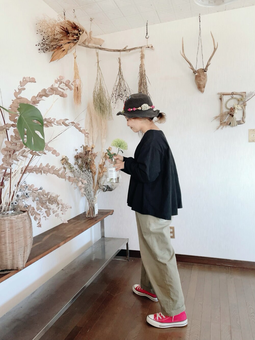 ブラック系のシャツ/ブラウス、グリーン系のパンツ、ピンク系のスニーカーを着用したレディースの冬コーディネートの2枚目の写真