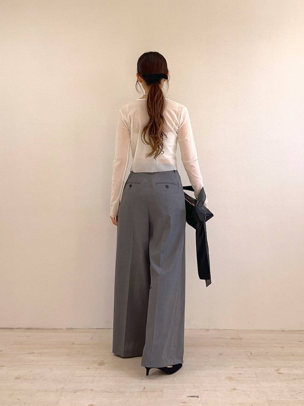 ブラック系のショルダーバッグ、ブラック系のサンダル、ホワイト系のキャミソールを着用したレディースの冬コーディネートの3枚目の写真