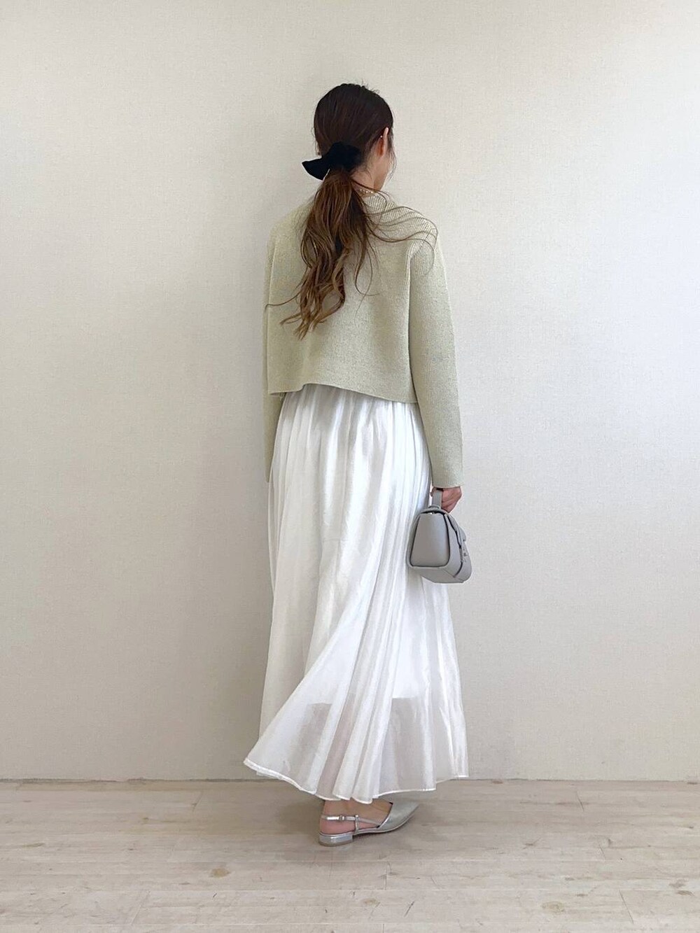 ベージュ系のカーディガン/ボレロ、ホワイト系のスカート、シルバー系のパンプスを着用したレディースの冬コーディネートの3枚目の写真