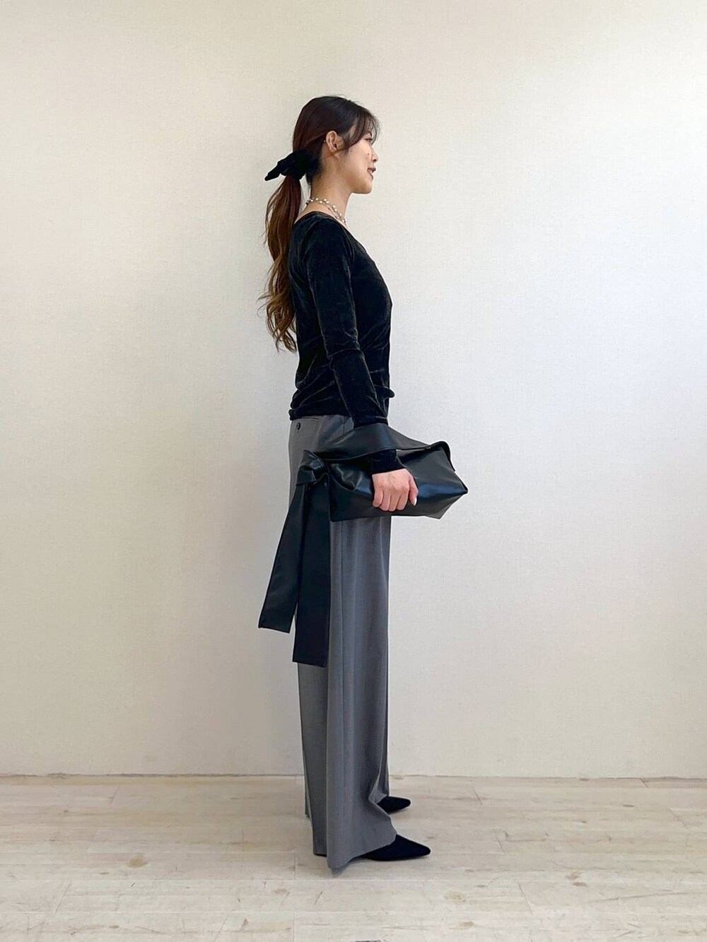 ブラック系のショルダーバッグ、ブラック系のサンダル、ブラック系のTシャツ/カットソーを着用したレディースの冬コーディネートの2枚目の写真