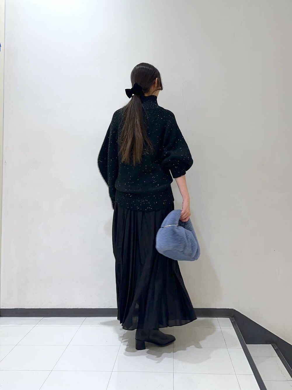 ブラック系のスカート、ブラック系のブーツ、ブラック系のニット/セーターを着用したレディースの冬コーディネートの3枚目の写真