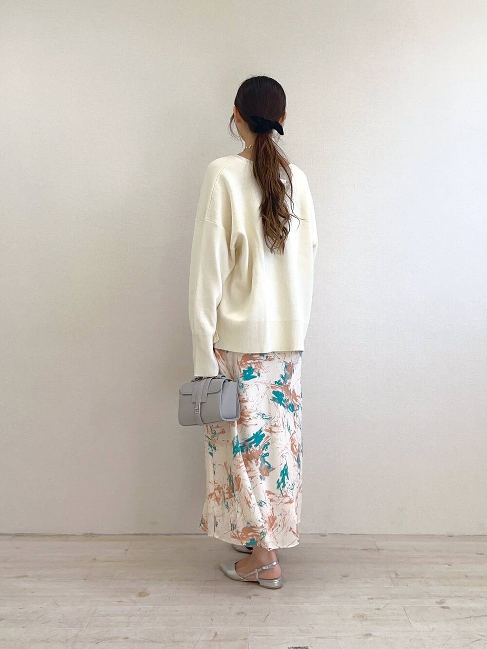 ホワイト系のニット/セーター、オレンジ系のスカート、シルバー系のパンプスを着用したレディースの冬コーディネートの3枚目の写真