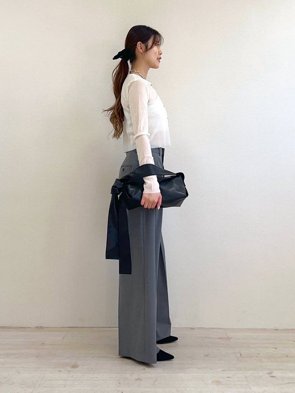 ブラック系のショルダーバッグ、ブラック系のサンダル、ホワイト系のキャミソールを着用したレディースの冬コーディネートの2枚目の写真