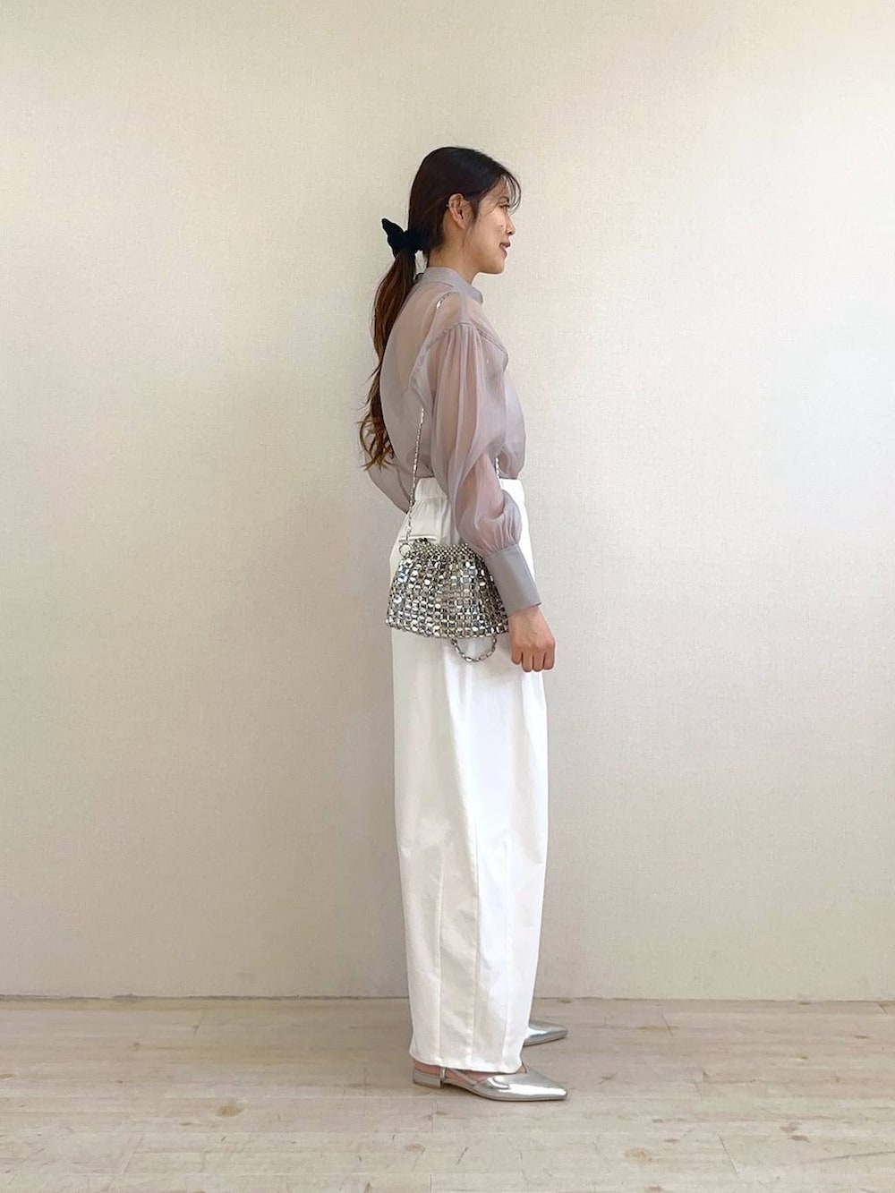 グレー系のシャツ/ブラウス、ホワイト系のその他パンツ、シルバー系のパンプスを着用したレディースの冬コーディネートの2枚目の写真