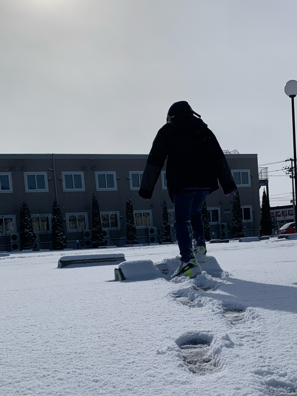 その他のスニーカー、ブラック系のトレンチコート、ブルー系のキャップを着用したメンズの春コーディネートの2枚目の写真