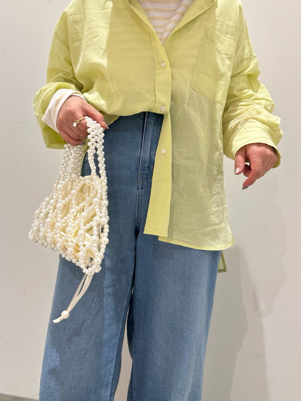 イエロー系のシャツ/ブラウス、ブラウン系のローファーを着用したレディースの夏コーディネートの3枚目の写真