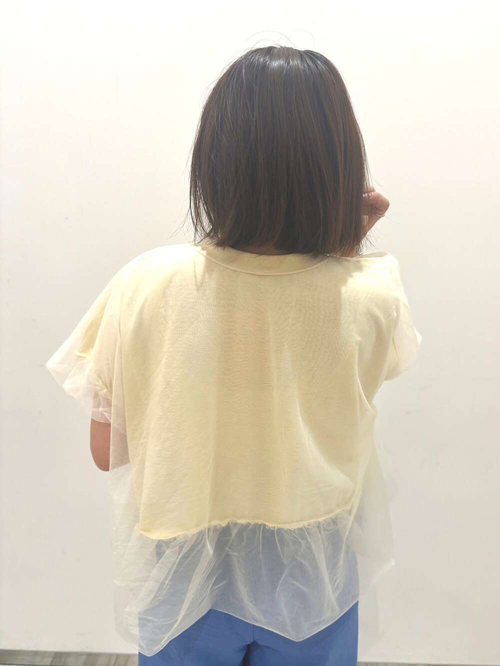 ホワイト系のボストンバッグ、ブルー系のスラックス、ホワイト系のTシャツ/カットソーを着用したレディースの春コーディネートの4枚目の写真