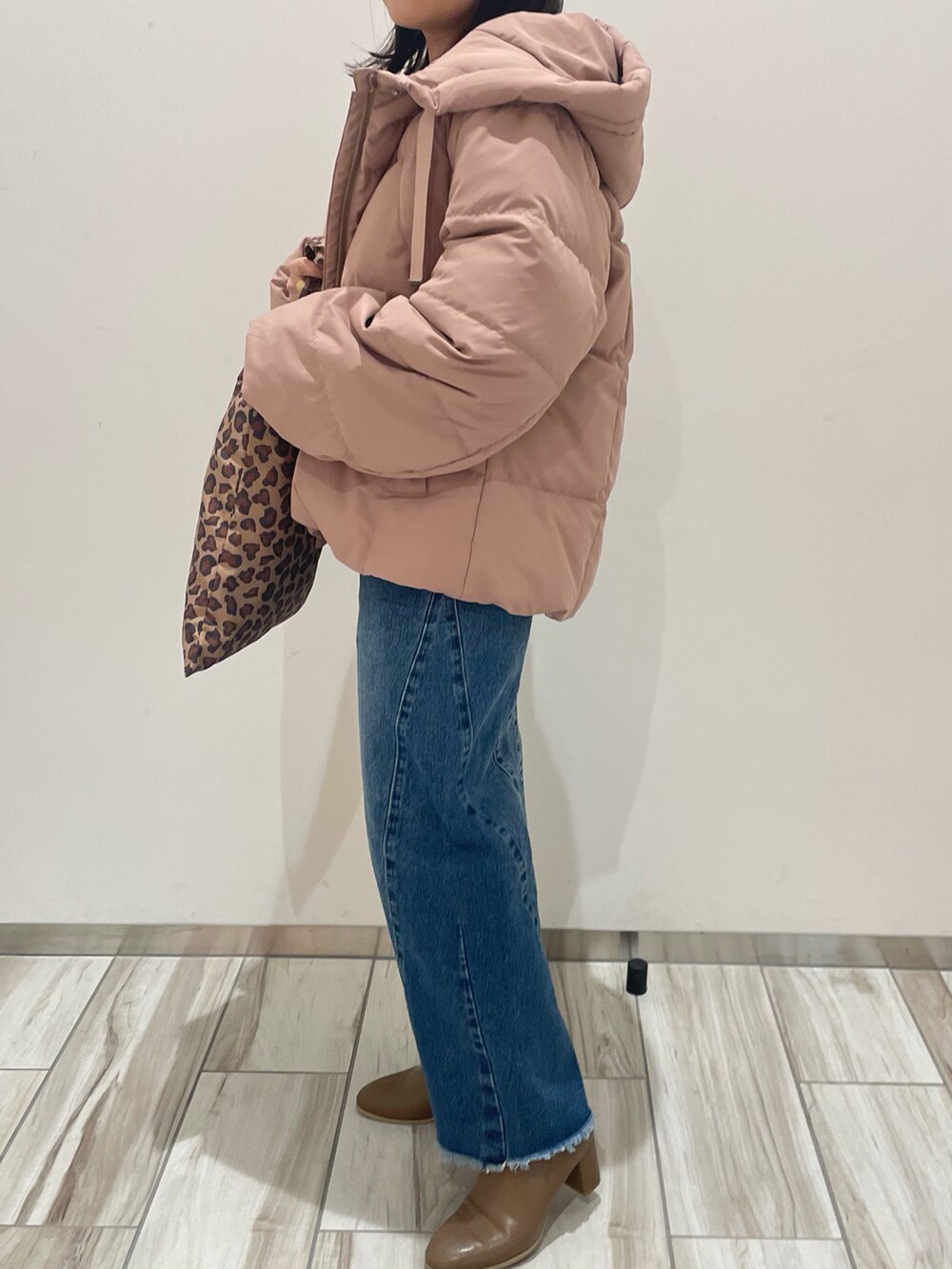 ピンク系のダウンジャケット/コート、ブルー系のデニムパンツ、ブラウン系のトートバッグを着用したレディースの冬コーディネートの4枚目の写真