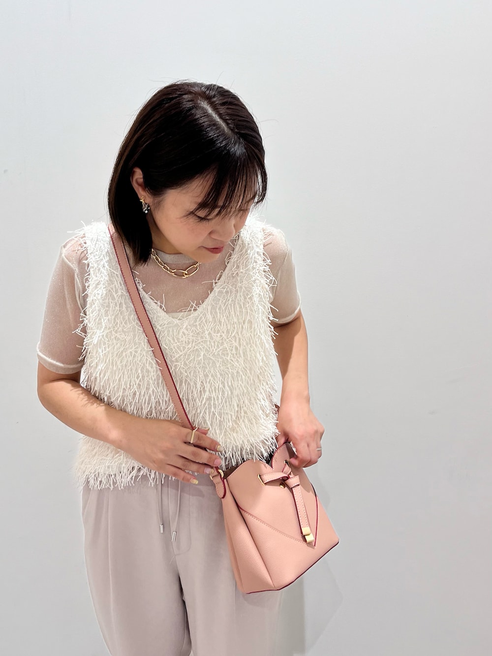 ホワイト系のタンクトップ、ホワイト系のTシャツ/カットソー、ホワイト系のスラックスを着用したレディースの夏コーディネートの2枚目の写真