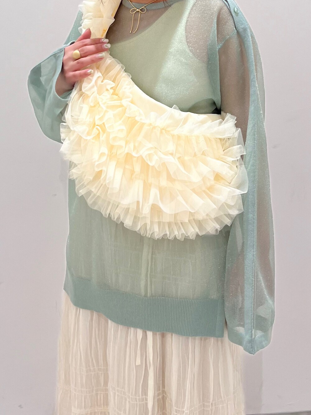 ホワイト系のショルダーバッグ、グリーン系のシャツ/ブラウス、ホワイト系のスカートを着用したレディースの春コーディネートの3枚目の写真