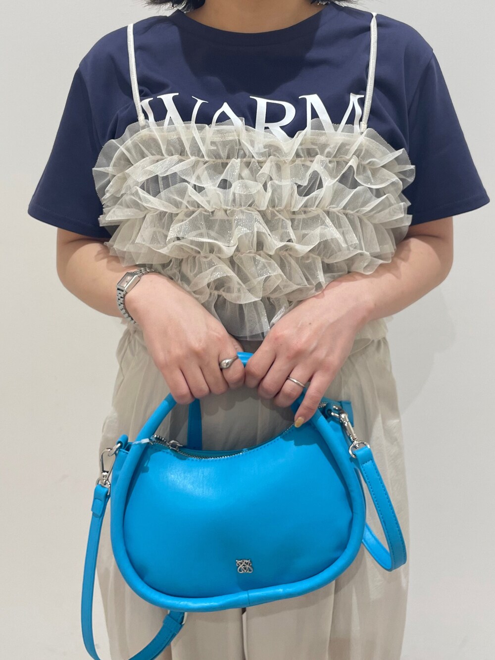 ホワイト系のキャミソール、ブルー系のTシャツ/カットソー、ベージュ系のその他パンツを着用したレディースの春コーディネートの2枚目の写真